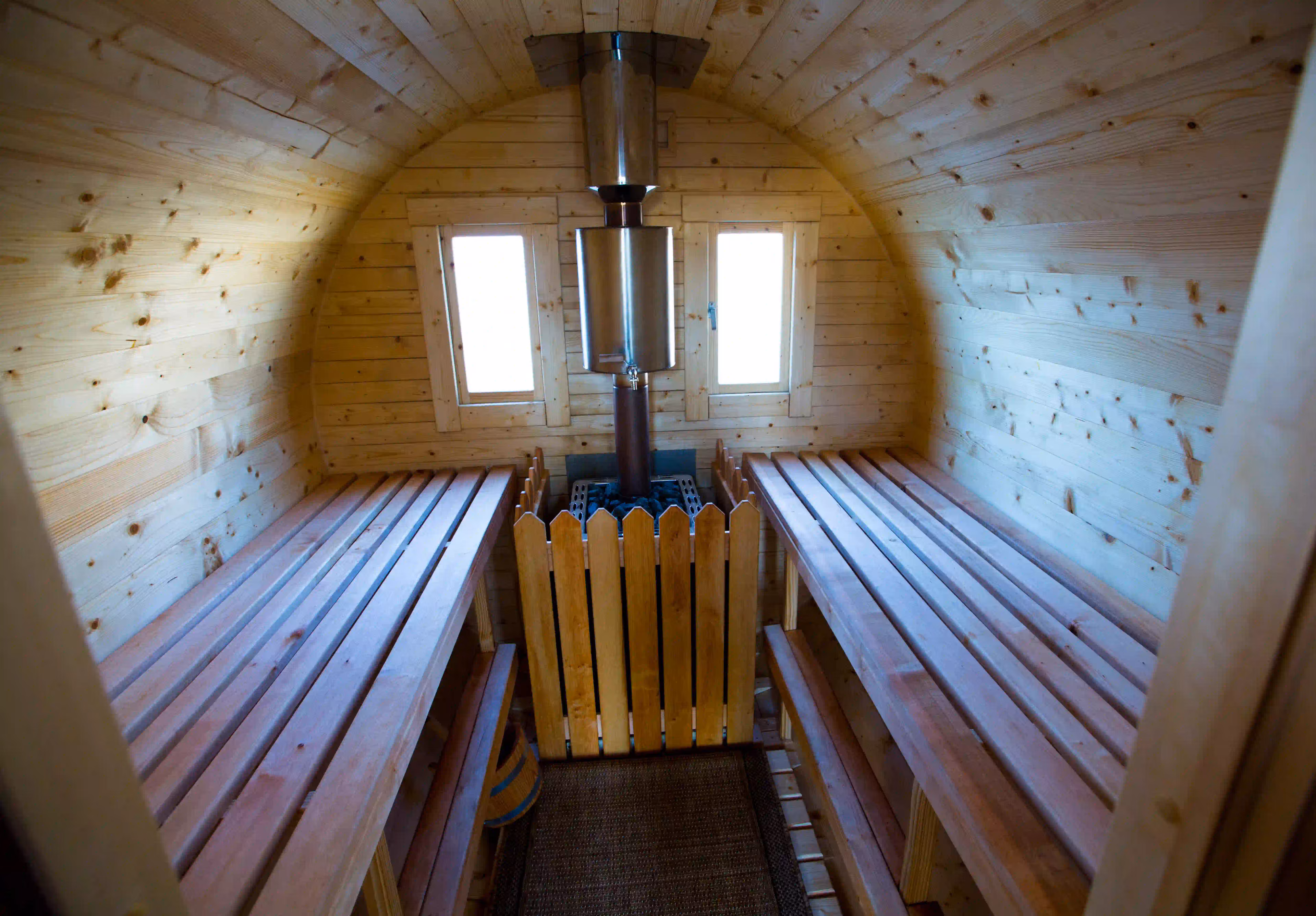 Blick in eine SpaFass-Sauna mit warmen Holzwänden und Saunaofen