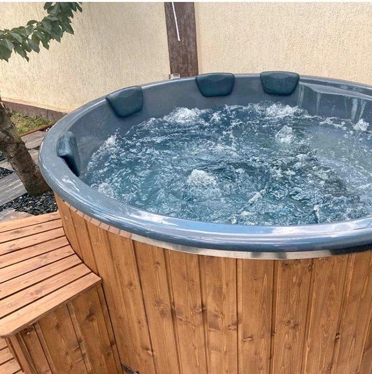 Massagefunktion im gefüllten Hot Tub und gepolsterte Kopfstützen