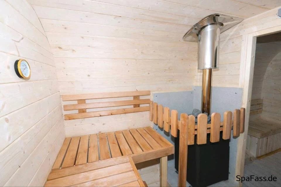Holzofen und Sitzbänke im Saunaraum